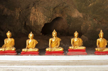 Buddha on stone babkground in cave of Thailandの写真素材