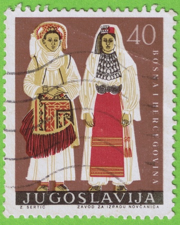 Postage stamp used and old Yugoslavia with value of 40 with two women dressed in traditional dress  Bosnia Herzegovinaの写真素材