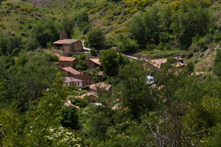 Beautiful view of small town or rural town of charming mountain spring. Surrounded by flowers, trees and vegetation. Church at the top. La Red. Leon. Spainの写真素材