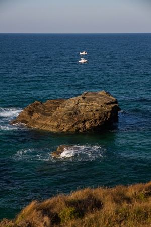 Cantabrian Sea coast in Spain with rocks and two small fishing boats の写真素材