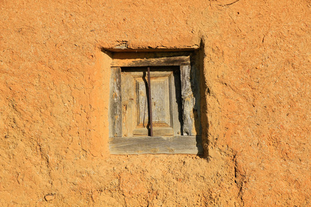 Wooden window with metal grille old adobe building