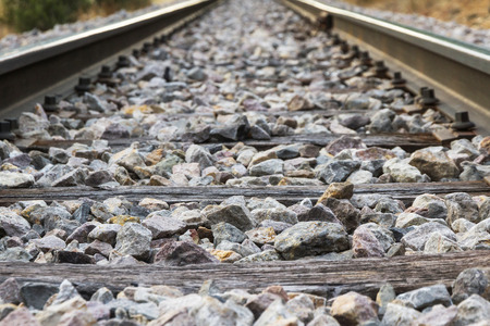 Detail of Railroad track with rails, transverse wooden sleepers and paving stones or ballastの写真素材