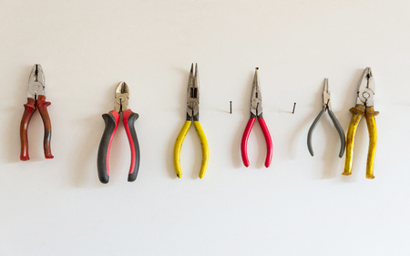 Collection of different pliers hanging on a panelの写真素材