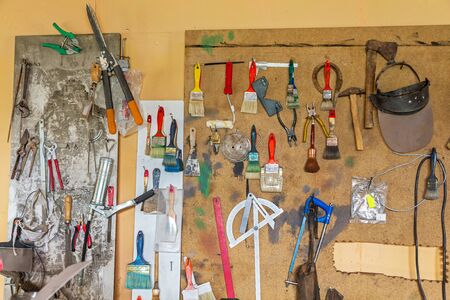 Many different tools used hanging on wooden board