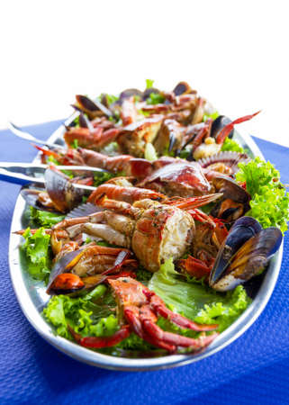 Varied seafood platter varied on the table (crab, mussels, scallops) decorated with green lettuce,...