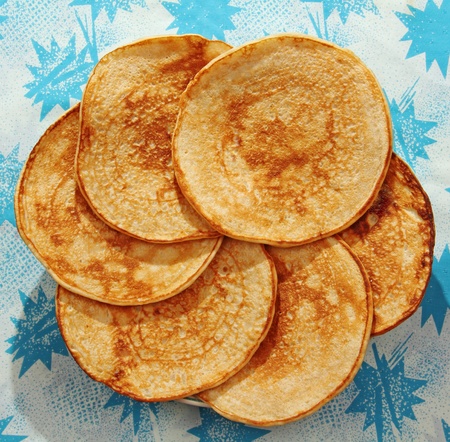 six pancakes, laid on the table around on the color blue background の写真素材