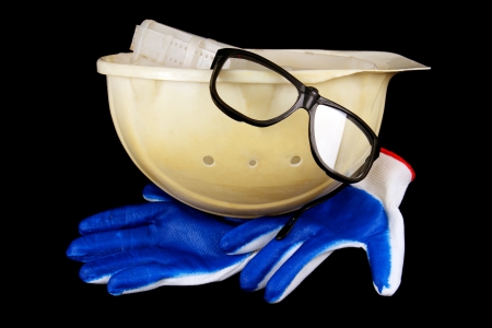 white construction helmet, gloves and goggles isolated on a black background の写真素材