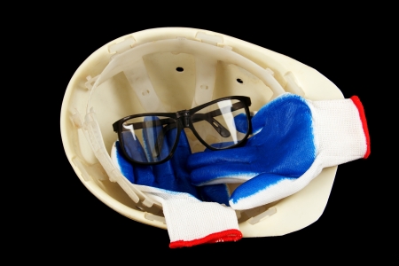 white construction helmet, gloves and goggles isolated on a black background の写真素材