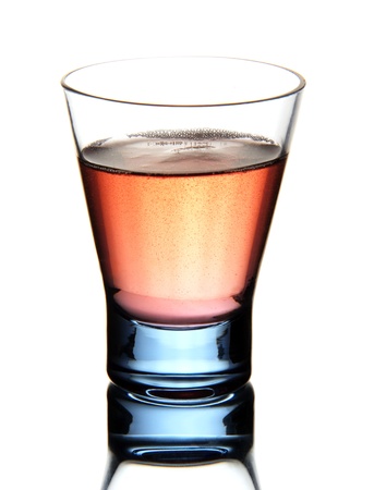 a shot glass with a drink of red color, isolated on white background の写真素材