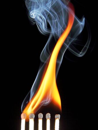 The fire and smoke from the burning and extinguished matches, photo on black background の写真素材