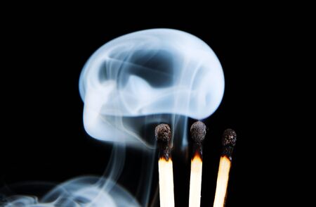 The fire and smoke from the burning and extinguished matches, photo on black background の写真素材