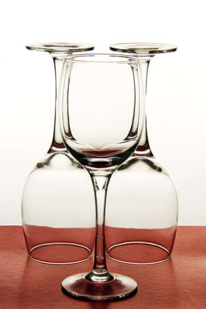 transparent empty wine glasses on the high leg on a colored background 