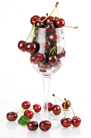 wet berries ripe red cherries on a table and in a glass container の写真素材