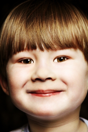 portrait of a little boy close-up photo on a black background の写真素材