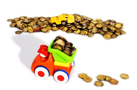 Gold coins are produced and transported with toy cars  white background の写真素材