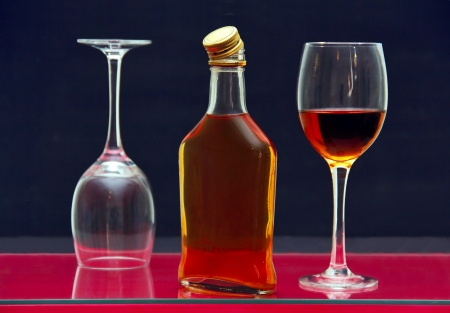 one bottle and two glasses of alcohol on the glass surface of the table.の写真素材