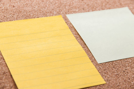 Yellow sticky notes on cork board with filled text blank space