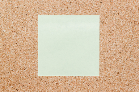 Yellow sticky note on cork board with filled text blank spaceの写真素材
