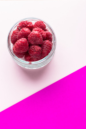 Jar of Raspberries on colorful paper backgroundの写真素材