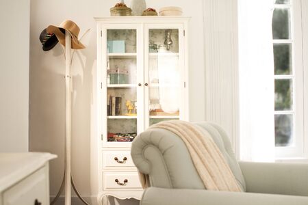 a hanging hat pole put near by a white display sideboard in bedroomの写真素材