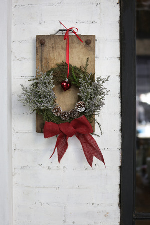 a christmas decoration hanging on the white brick wallの写真素材