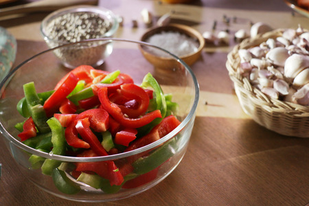 sliced bell pepper prepared for cooking in a glass bowl with another ingredient