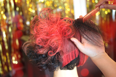 hairdresserâs hand combing a part of curling hair in hairdo classの写真素材