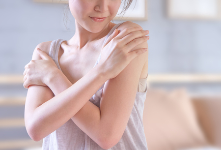 young woman touching her shoulder prouding with her healthy skin after applying the creamの写真素材