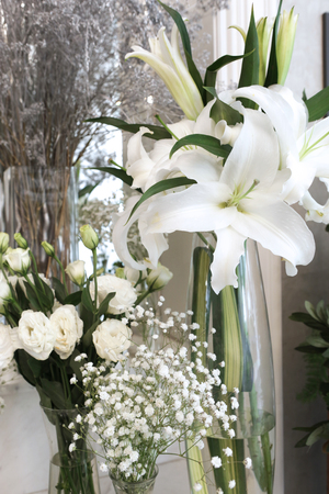 many glass vases are contained by lilies, lisianthus and gypsophila for decorated living roomの写真素材