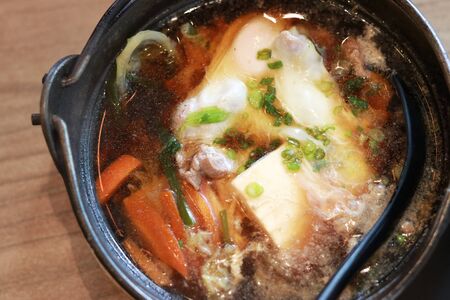 a famous Japanese food name âSukiyakiâ served with small hot pot in restautantの写真素材
