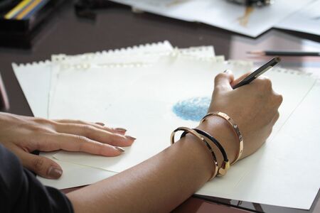 fashion designer is drawing some detail for decorate on dressの写真素材