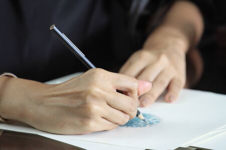 fashion designer is drawing a blue sign for decorate on the dressの写真素材