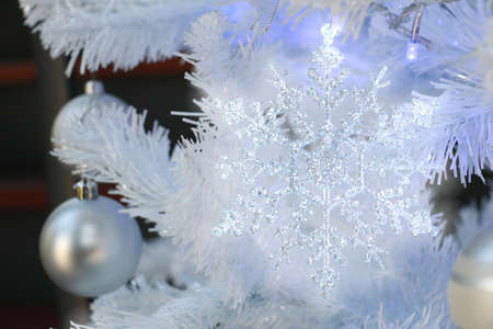 a christmas wreath decorated with a golden hear deer, white snowflakes and red balls put on a stand in hall wayの写真素材