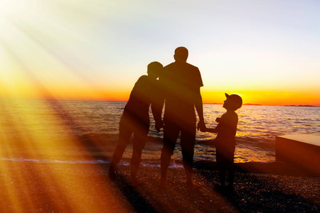 Family Silhouette. Sunset at sea.の写真素材