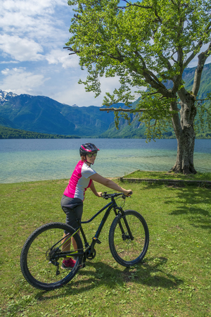 Family active vacation. Green destination. Cycling in the national park. Active lifestyle, healthy lifestyle. Family by the lake, mountains in the background.の写真素材