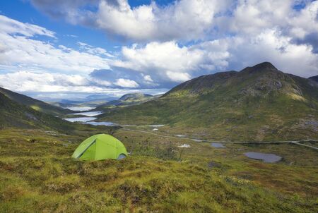 Camping in the nature. Campground in the mountains with the beautiful view over the lakes and river in the background.の写真素材