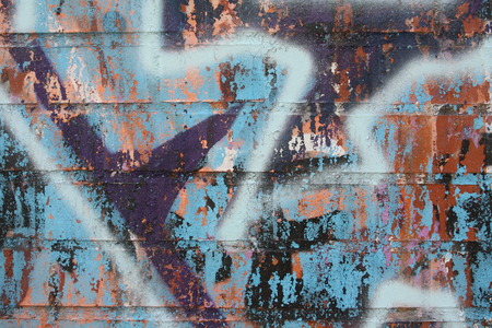 Peeling graffiti on a brick wall