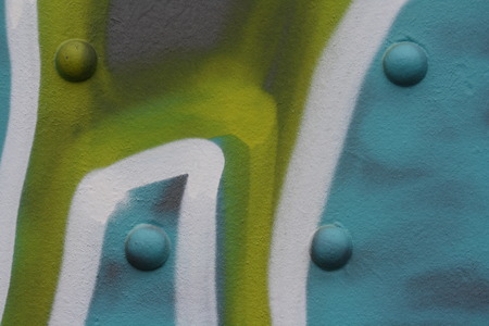 Metal surface with rivets and graffiti
