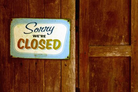 Retro rusty vintage metal closed sign on wooden brown shop windowの写真素材