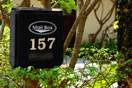 Black antique mailbox with natural green background, letterbox