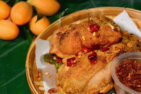 Fried chicken and roasted chili paste in a bamboo tray with bon leaf. Thai food.