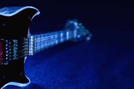 guitar clock resting against classic blue background with copy space