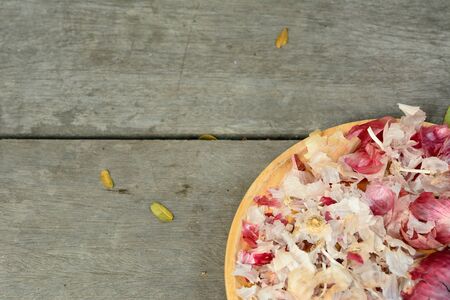 Garlic peel in yellow dish on wooden floor background.の写真素材