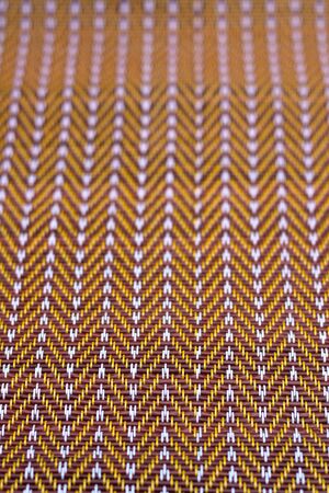 Plastic weave mat in brown color tone pattern background.