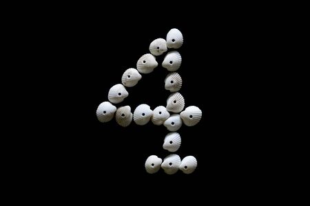 Sign number four from white cockles isolated on black background.の写真素材