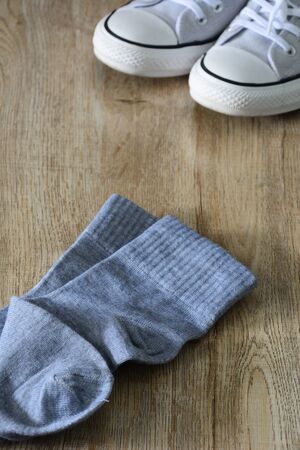 White color canvas shoes and gray socks isolated on wooden background.の写真素材