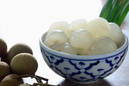 Longan in syrup and pandan leaf on wooden background. Traditional thai dessert.