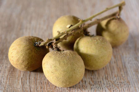 Longan in syrup and pandan leaf on wooden background. Traditional thai dessert.