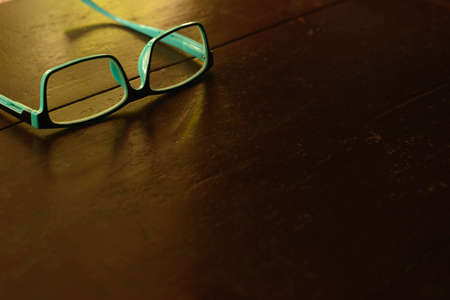 Blue eye glasses on wooden brown table.の写真素材