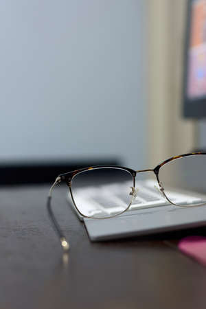 Keyboard and eyeglasses on office desk with natural background.の写真素材